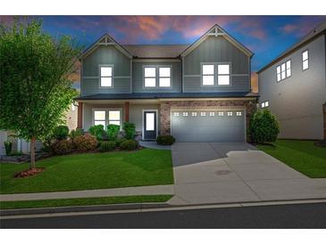 Charming two-story home features a stone accent garage and manicured front lawn at 5751 Green Arbor Way, Sugar Hill, GA 30518