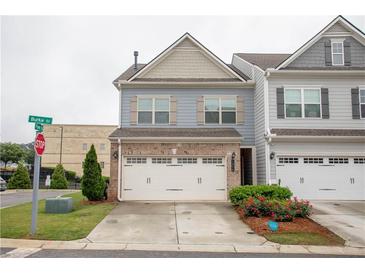 Charming two-story townhome featuring a two-car garage, well-maintained lawn, and lovely landscaping at 1024 Burke St # 56, Lawrenceville, GA 30046