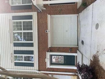 Charming townhouse with brick facade, featuring shuttered windows, a garage, and welcoming front door at 2253 Dillard Xing, Tucker, GA 30084
