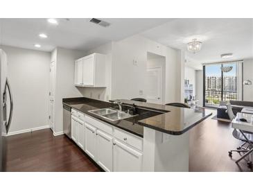 Modern kitchen with stainless steel appliances, granite countertops, and breakfast bar overlooking the living area at 3040 Peachtree Nw Rd # 713, Atlanta, GA 30305