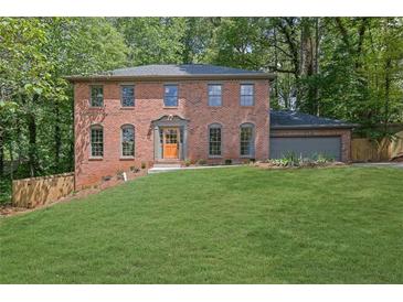 Brick home with a beautiful lawn, a two-car garage and an elegant front entryway at 1430 Dallas Circle Sw, Marietta, GA 30064