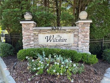 Stone community sign for The Wiltshire with manicured landscaping at 3047 Lenox Ne Rd # 2105, Atlanta, GA 30324