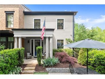 Charming home featuring a manicured front yard, covered porch with columns and an American flag at 727 Hammond Dr, Woodstock, GA 30188