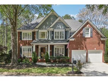 Charming two-story brick home with a well-manicured lawn, professional landscaping, and attached two car garage at 8640 Amsbury Way, Cumming, GA 30041