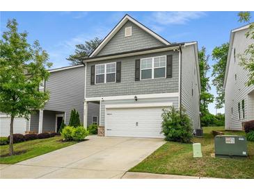 Charming two-story home with gray siding, a two-car garage, and a well-manicured lawn at 4422 Richmond Se Ct, Stone Mountain, GA 30083