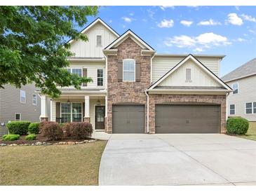 Beautiful two-story home featuring stone accents, a two-car garage, and a well-manicured lawn at 5760 Palmtree Pass, Cumming, GA 30040