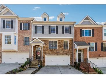 Charming three-story townhome with stone facade, arched entryway, and attached two-car garage at 1236 Brickton Nw Dr, Atlanta, GA 30318