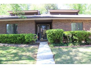 Charming brick home featuring manicured shrubbery and a well-maintained front yard, creating excellent curb appeal at 1457 Stoneleigh Cir, Stone Mountain, GA 30088