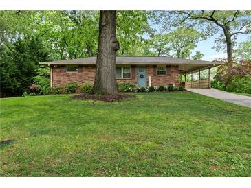 Charming brick home featuring a well-manicured lawn and a convenient covered carport at 2337 Elmwood Se Cir, Atlanta, GA 30339