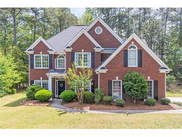 Beautiful two-story red brick home with black shutters and lush landscaping in a sought-after neighborhood at 4319 Silver Peak Pkwy, Suwanee, GA 30024