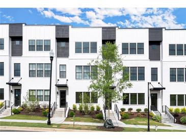Modern townhome exterior features white brick, black window frames, and professionally landscaped front yard at 673 Soul Aly # 146, Alpharetta, GA 30009