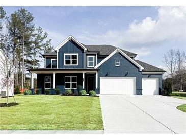 Beautiful two-story home featuring a dark blue exterior with a well-manicured lawn and two-car garage at 3548 Cedarvale Ct, Powder Springs, GA 30127