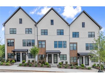 Charming townhome exterior boasts brick facade, black trim, and manicured landscaping at 656 Soul Aly # 101, Alpharetta, GA 30009