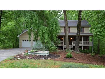 Charming two-story home with a well-maintained lawn, two car garage and landscaped flower beds in a wooded surrounding at 553 Old Mill Ct, Norcross, GA 30093