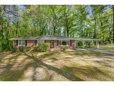 Charming single-story brick home with a spacious carport and mature trees at 618 Buchanan Hwy, Dallas, GA 30157