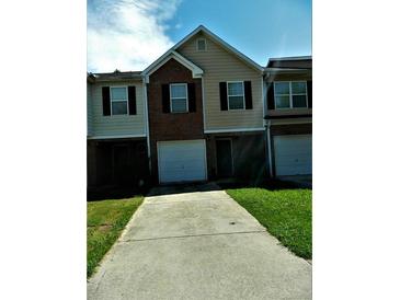 Charming townhome with a one-car garage and well-manicured front lawn at 615 Magnolia Gardens Walk, Mcdonough, GA 30253