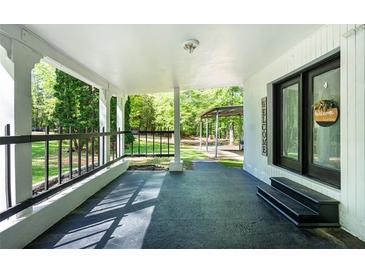 Inviting front porch with black railings, welcome sign, and views of the landscaped yard at 1369 N Highway 16, Whitesburg, GA 30185