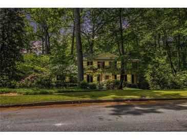 Charming two-story brick home with manicured lawn and mature trees offers a serene setting at 4111 Mcclatchey Ne Cir, Atlanta, GA 30342