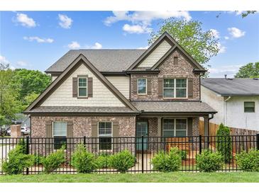 Charming two-story home with brick facade, manicured lawn, and black iron fence at 461 Silver St, Buford, GA 30518