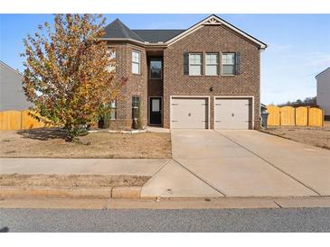 Two story brick home with a two car garage and manicured front yard at 165 Twin Lakes Dr, Covington, GA 30016