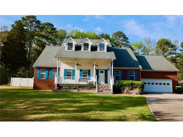 Charming two-story home with a welcoming front porch, vibrant blue shutters, and well-manicured lawn at 2949 Lake Spivey Pkwy, Jonesboro, GA 30236