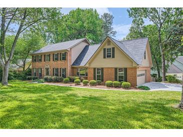 Charming brick home featuring a well-manicured lawn and mature trees, offering a serene and inviting curb appeal at 3635 Norwich Dr, Tucker, GA 30084