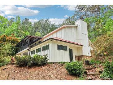 Modern white two-story house featuring a red roof, a chimney, and a black iron balcony at 5250 Aubrey Ln, Cumming, GA 30028