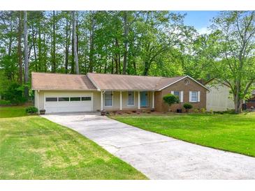 Charming brick and siding home with a well-manicured lawn and attached garage at 1773 Kimberly Sw Dr, Marietta, GA 30008