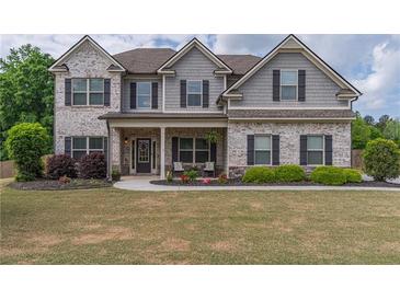 Charming two-story home with brick and gray siding, a welcoming front porch, and a well-manicured lawn at 432 Creekside Park, Covington, GA 30014
