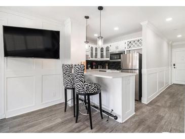 Modern kitchen featuring stainless steel appliances, white cabinetry, and breakfast bar with unique zebra-print bar stools at 215 Piedmont Ne Ave # 2210, Atlanta, GA 30308