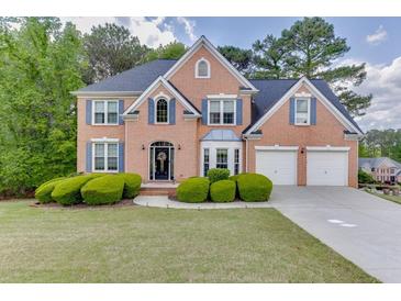 Charming brick home with a well-manicured lawn and beautiful landscaping, creating inviting curb appeal at 4290 Grand Teton Pkwy, Suwanee, GA 30024