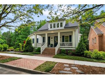 Charming two-story home with a welcoming front porch, landscaped yard, and brick pathway at 5134 Pratt Sw St, Covington, GA 30014