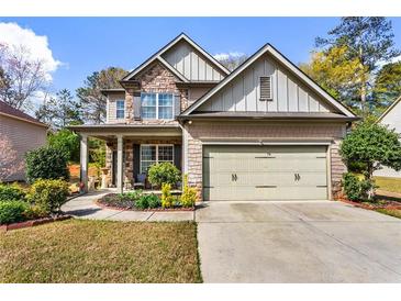 Charming two-story home with a stone and siding facade, a covered front porch, and a well-manicured lawn at 635 Crosswinds Cir, Marietta, GA 30008