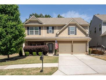 Charming two-story home with a manicured front lawn, a two-car garage, and a welcoming entrance at 120 Park Village Dr, Canton, GA 30114