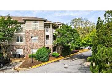 Exterior view of a brick apartment building with well-maintained landscaping and a paved parking area in front at 2700 Pine Tree Ne Rd # 1214, Atlanta, GA 30324