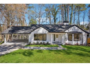 Charming, updated home with white brick, black trim, covered parking, and manicured lawn at 335 Amberidge Trl, Atlanta, GA 30328