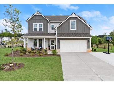 Charming two-story home with a well-manicured lawn, a basketball hoop, and a two-car garage at 837 Porches Way, Dacula, GA 30019