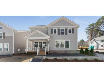 Charming two-story home with gray siding, a covered front porch, and manicured landscaping at 919 East Green Ln, Clarkston, GA 30021