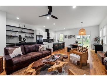 Open concept living room featuring hardwood floors, stylish decor, and kitchen with modern finishes at 210 Locust Ne St, Atlanta, GA 30317