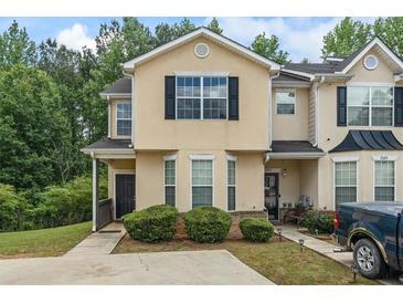 Charming townhome with a well-maintained lawn and a classic facade, accented by dark shutters and trim at 7322 Bridlewood Ct, Jonesboro, GA 30236