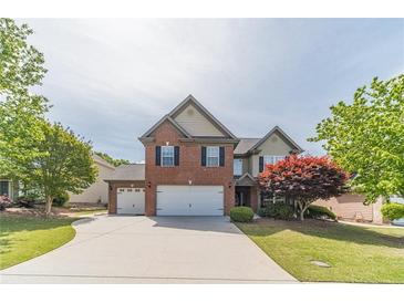 Charming brick and siding home with a well-manicured lawn and a two-car garage at 230 Wild Barley Way, Loganville, GA 30052