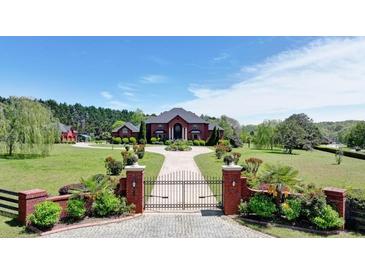 Stately brick home featuring a circular driveway and manicured lawn at 5010 Heardmont Trace Rd, Cumming, GA 30028
