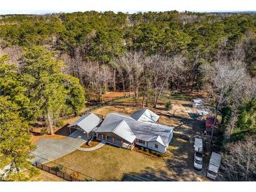 Expansive aerial view of property featuring the house, carport, and surrounding wooded acreage at 5035 Villa Rica Hwy, Dallas, GA 30157