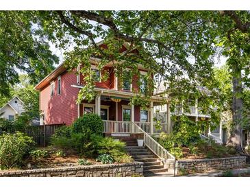 Charming two-story red home with inviting front porch and well-manicured landscaping at 604 Mead Se St, Atlanta, GA 30312