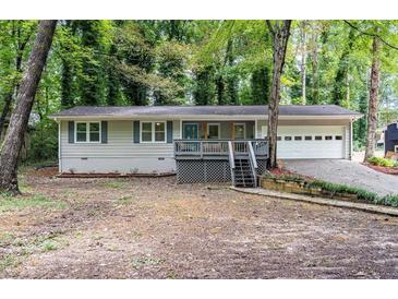 Charming ranch home with a covered porch, blue shutters, manicured yard, and a two-car garage at 111 John Christopher Dr, Alpharetta, GA 30009