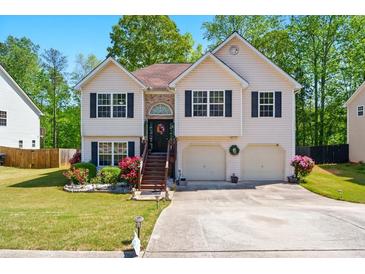 Charming split-level home featuring a well-manicured lawn, inviting front door, and attached two-car garage at 1010 Augusta Woods Dr, Douglasville, GA 30134