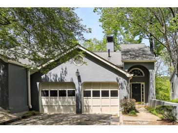 Charming home featuring a two-car garage and beautifully painted exterior with lovely trees surrounding the property at 3794 Ashford Lake Ne Ct, Brookhaven, GA 30319