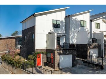 Modern townhome with a brick facade, white siding, and a bright red front door at 2498 Perry Nw Blvd, Atlanta, GA 30318