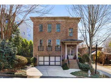 Brick home featuring a two-car garage, small front porch, and multiple stories at 540 Woodall Ne Ave, Atlanta, GA 30306