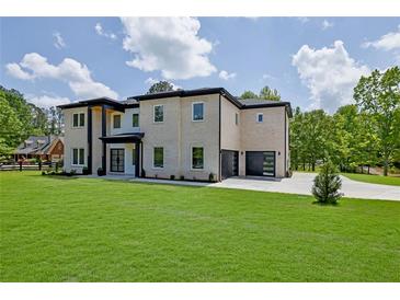 Stunning two-story home with a manicured lawn, modern garage doors, and a sleek black and white design at 4881 Bill Cheek Rd, Auburn, GA 30011